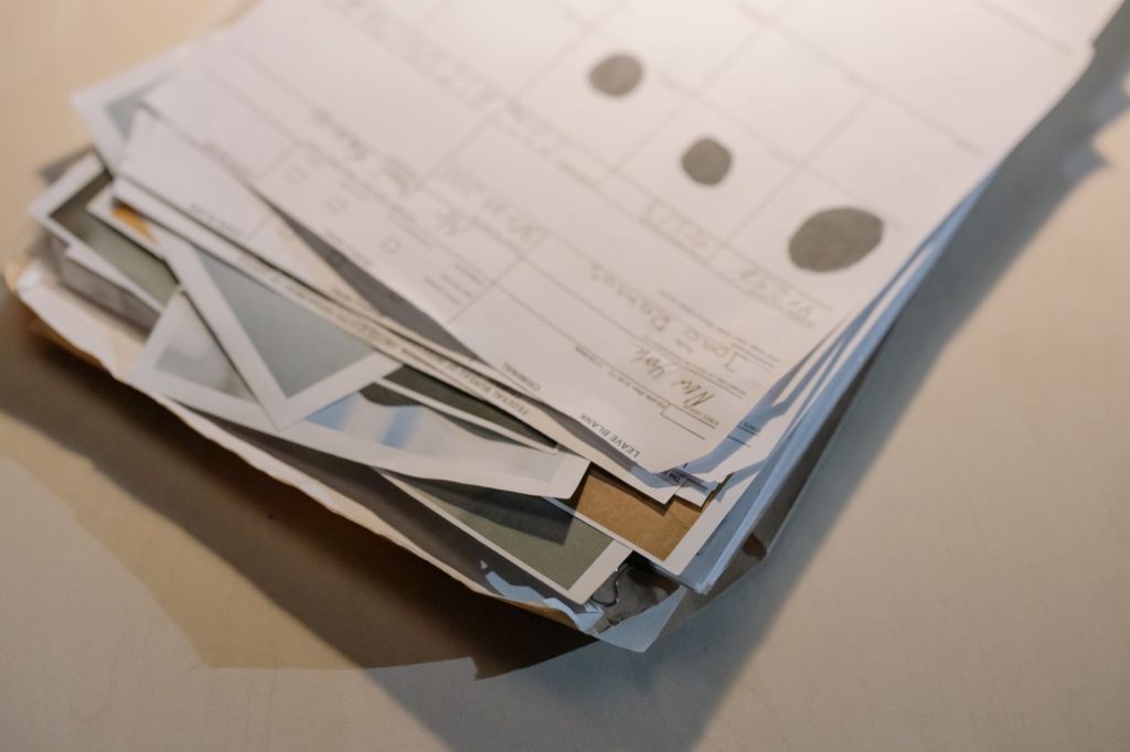A loose stack of paper invoices and printed forms piled on a desk