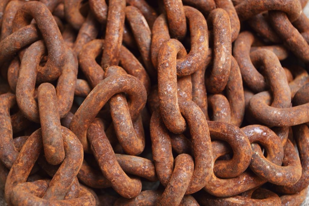 A tangled pile of heavy rusted chain links filling the frame